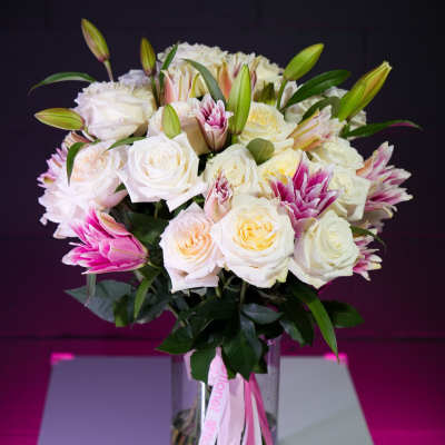 Bouquet of white and pink roses with lilies in a glass vase