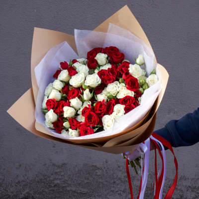Bouquet of red and white roses wrapped in brown paper