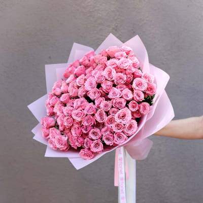 Large bouquet of pink roses wrapped in pale pink paper