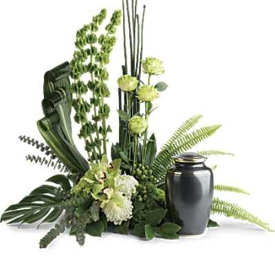 Tall green and white floral arrangement with Bells of Ireland beside a dark cremation urn
