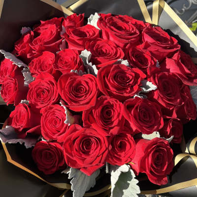 Bouquet of red roses wrapped in black and gold paper