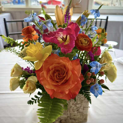 Colorful mixed flower arrangement in a square vase