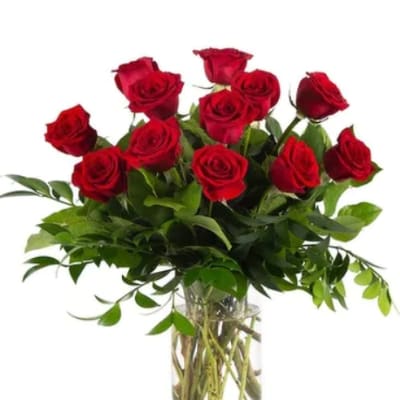 Red roses arranged in a clear glass vase