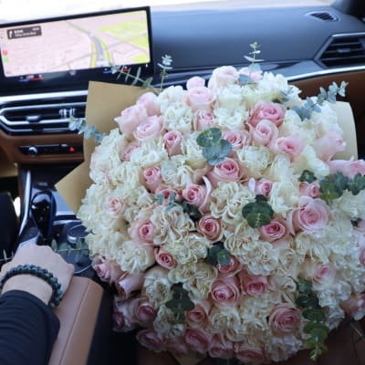 Large bouquet of pink and white roses in a car seat