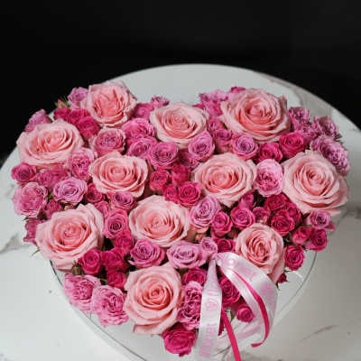 Heart-shaped box of pink roses and spray roses with ribbon