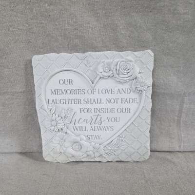 Gray stone sympathy plaque with heart-shaped inscription and carved flowers