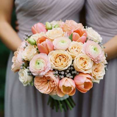 Peach and blush bridal bouquet with roses, ranunculus, and tulips