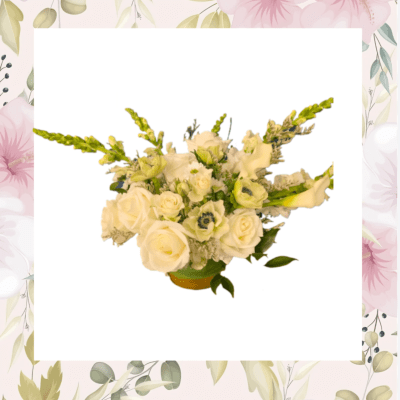Cream rose bouquet with white calla lilies in a low container
