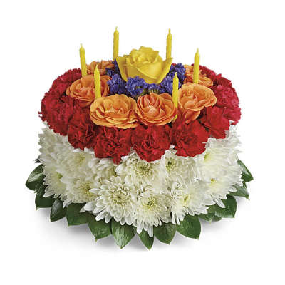 Round cake-shaped floral arrangement with colorful blooms and yellow candles on top
