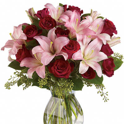 Bouquet of pink lilies and red roses in a clear glass vase