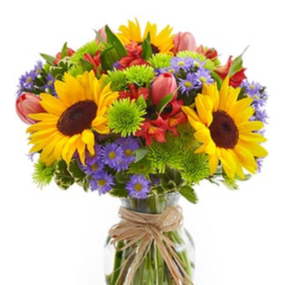 Bright mixed bouquet with sunflowers, purple daisies, and a glass vase tied with raffia