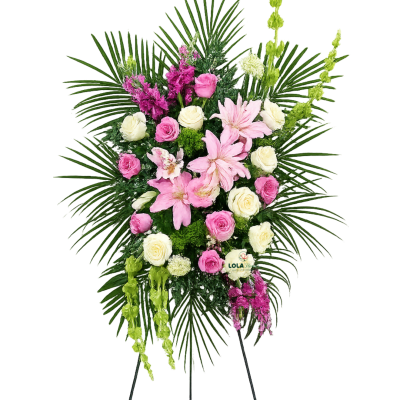 Tall standing spray of pink lilies, pink and cream roses, and green accents on a black easel