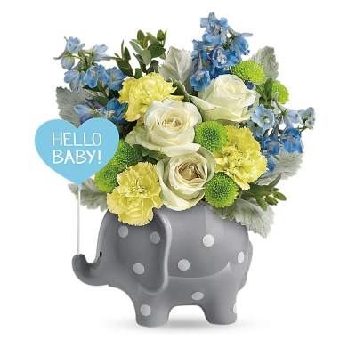 Baby-themed bouquet with white roses and yellow flowers in a gray polka dot elephant vase.