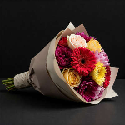 Bouquet of mixed roses and gerbera daisies wrapped in paper