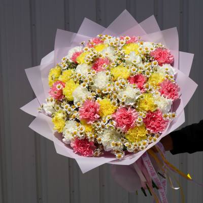 Large bouquet of pink, yellow, and white carnations with tiny daisies