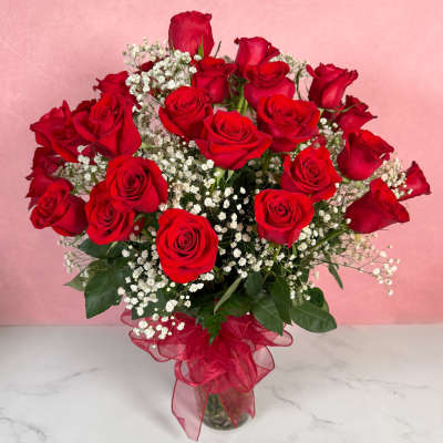 Bouquet of red roses with white baby's breath in a glass vase