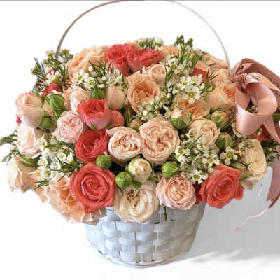 Basket of pink and peach roses with a ribbon handle