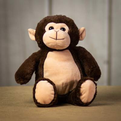 Brown and beige plush monkey toy seated on a neutral surface