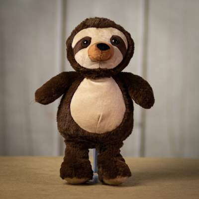 Brown and cream sloth plush toy standing upright on a neutral surface