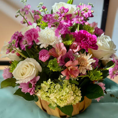 Mixed pink and white flower arrangement in a pumpkin-shaped container