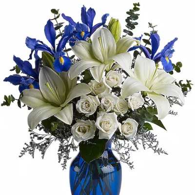 White lilies, white roses, and blue irises in a cobalt vase