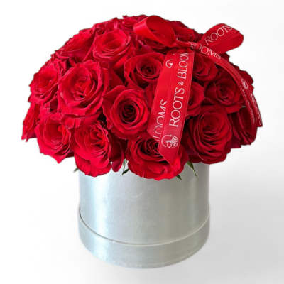 Red rose bouquet in a silver hatbox with a red ribbon
