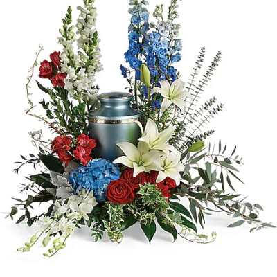 Red, white, and blue floral arrangement around a blue urn