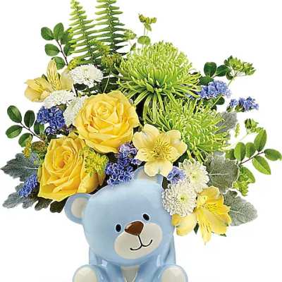 Yellow and white flower arrangement in a blue teddy bear container