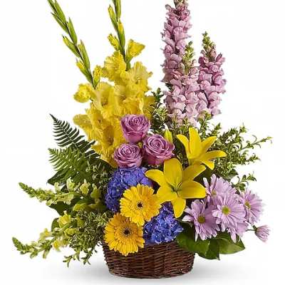 Basket arrangement with yellow lilies, purple roses, blue hydrangeas, and lavender flowers