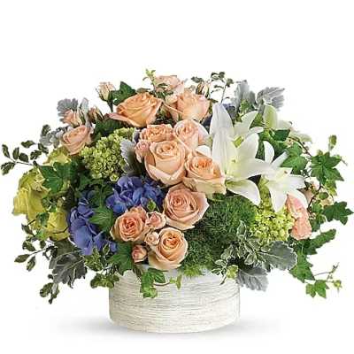 Peach roses and white lilies in a round white vase