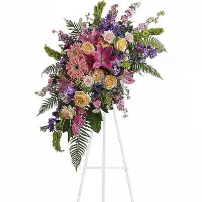 Large standing floral spray with pink, purple, and yellow flowers on an easel