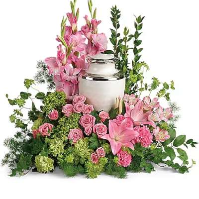 Pink floral funeral urn arrangement with lilies, roses, and greenery