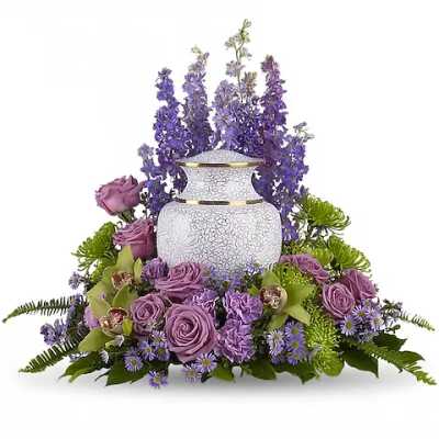 Purple floral arrangement around a white urn-shaped vase