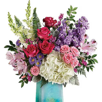 Mixed bouquet of roses, hydrangeas, and purple blooms in a turquoise vase