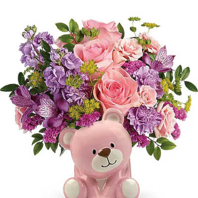 Pink teddy bear vase holding pink and purple flowers