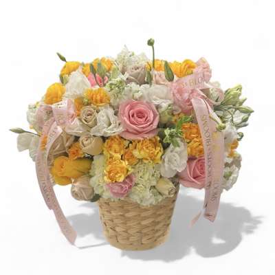 Basket arrangement of pink, white, and yellow roses with ribbons