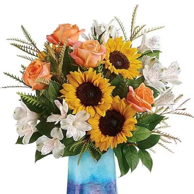 Sunflowers, peach roses, and white alstroemeria in a blue glass vase