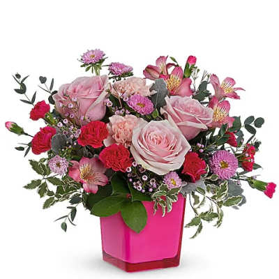 Pink roses and mixed flowers in a bright pink vase