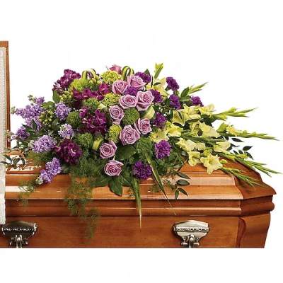 Purple and yellow floral spray on a wooden casket