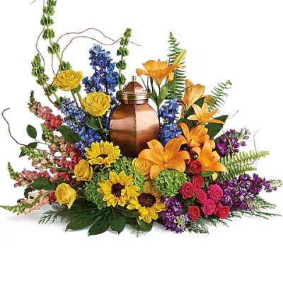 Colorful floral arrangement around a copper urn with yellow, orange, blue, pink, and purple blooms