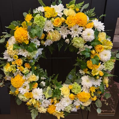 Large yellow and white floral wreath with mixed blooms