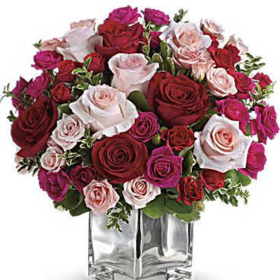 Bouquet of red, pink, and white roses in a clear square vase