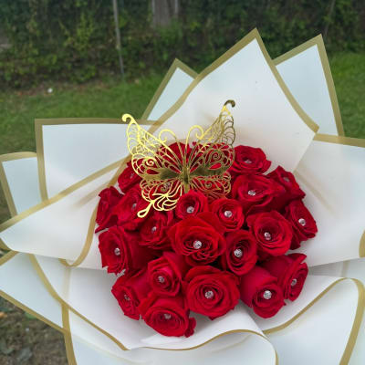Red rose bouquet with a gold butterfly topper and white-gold wrapping