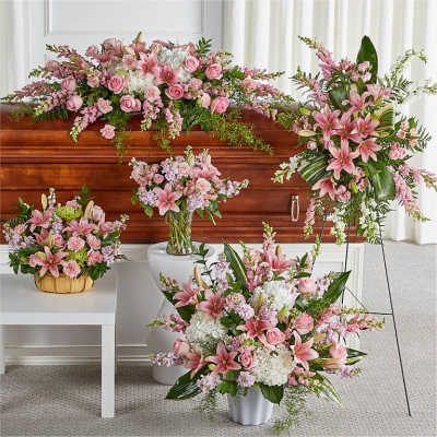 Pink floral funeral casket spray with matching arrangements