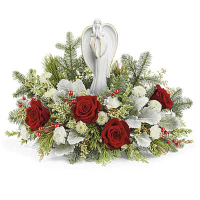 Red roses and white flowers arranged around a white angel figurine
