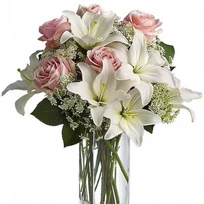 Pink roses and white lilies arranged in a clear glass vase