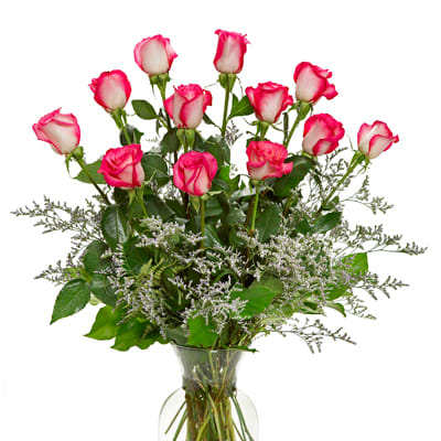Pink and white roses arranged in a clear glass vase