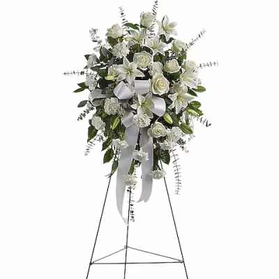 White floral standing spray on an easel with ribbon streamers