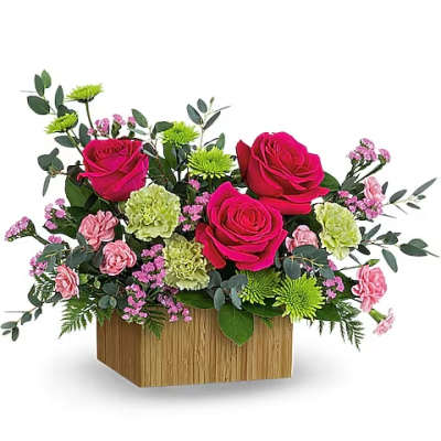Pink roses and carnations in a wooden box