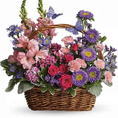 Basket arrangement of pink and purple flowers with butterfly picks